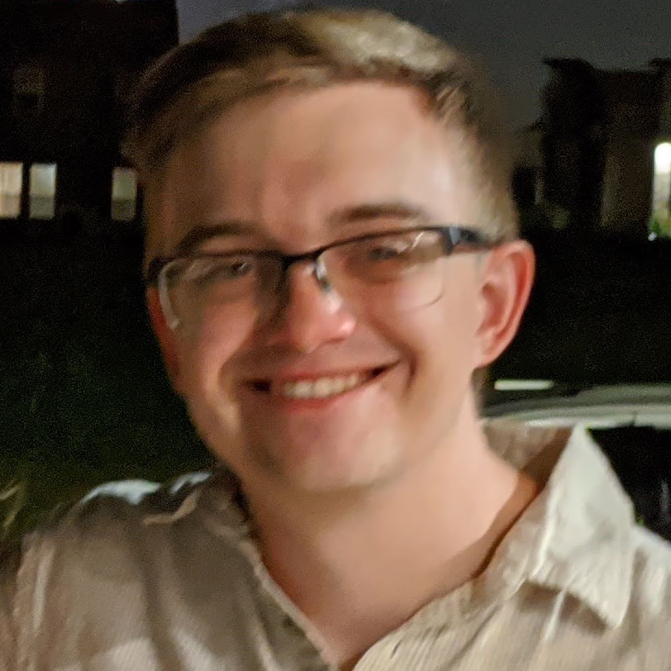 I'm a man with glasses in his late-20s, pictured outside (at the Texas State Fair), smiling at the camera, with the image zoomed into my face and shoulders